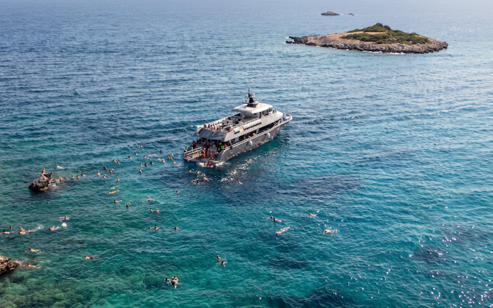 Cruise ship near Symi Island with swimmers in St. George Bay, Rhodes.