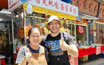 Local vendor and tourist smiling at a food stall in Shenzhen market.