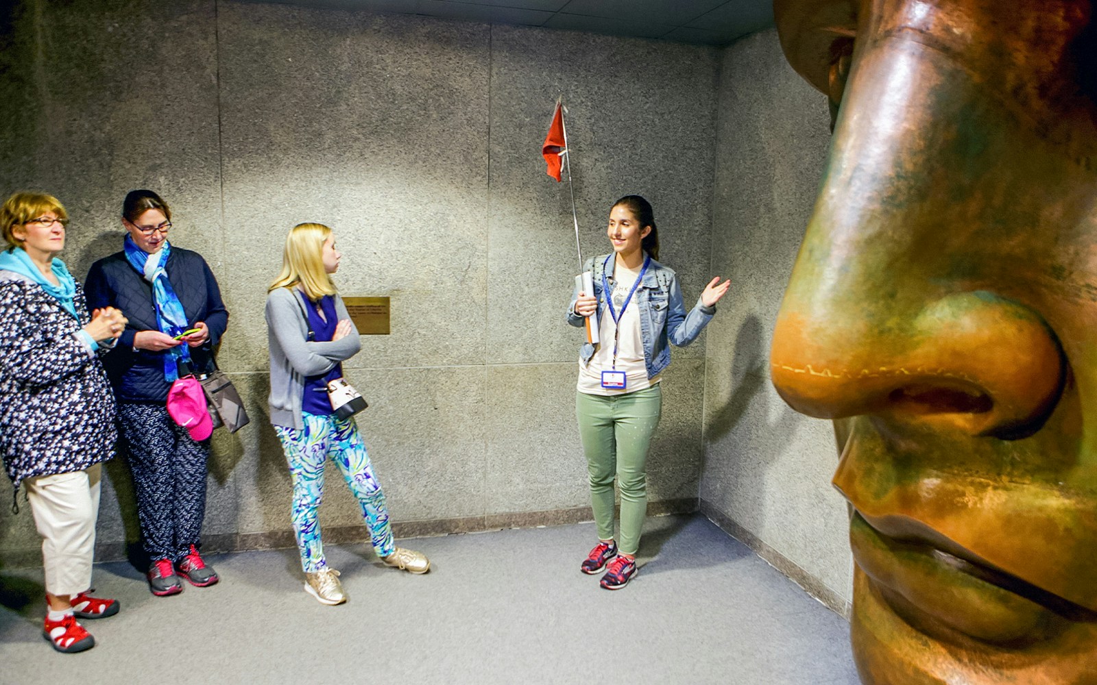 Guide explaining to tourists inside the Statue of Liberty museum.