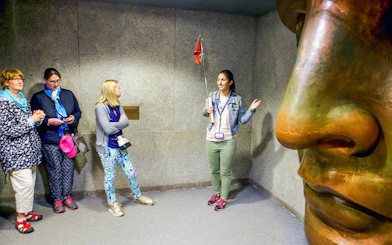 Guide explaining to tourists inside the Statue of Liberty museum.