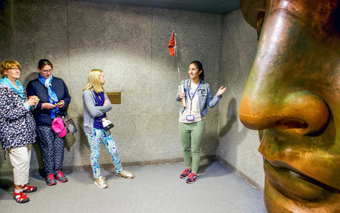 Guide explaining to tourists inside the Statue of Liberty museum.