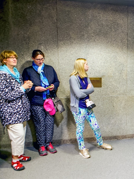 Guide explaining to tourists inside the Statue of Liberty museum.