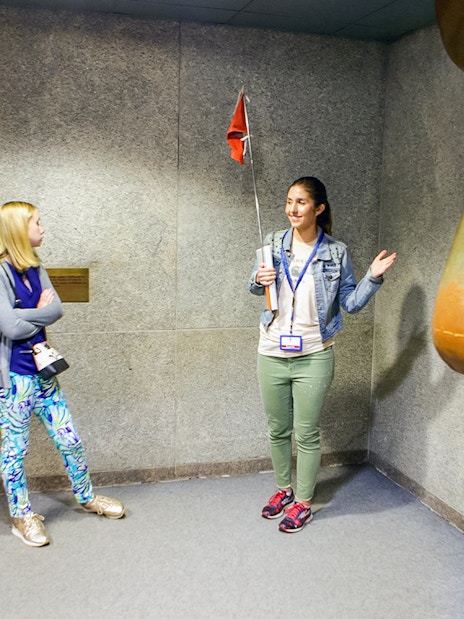 Guide explaining to tourists inside the Statue of Liberty museum.