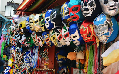 Colorful Lucha Libre masks displayed at a market stall in Arena Mexico.