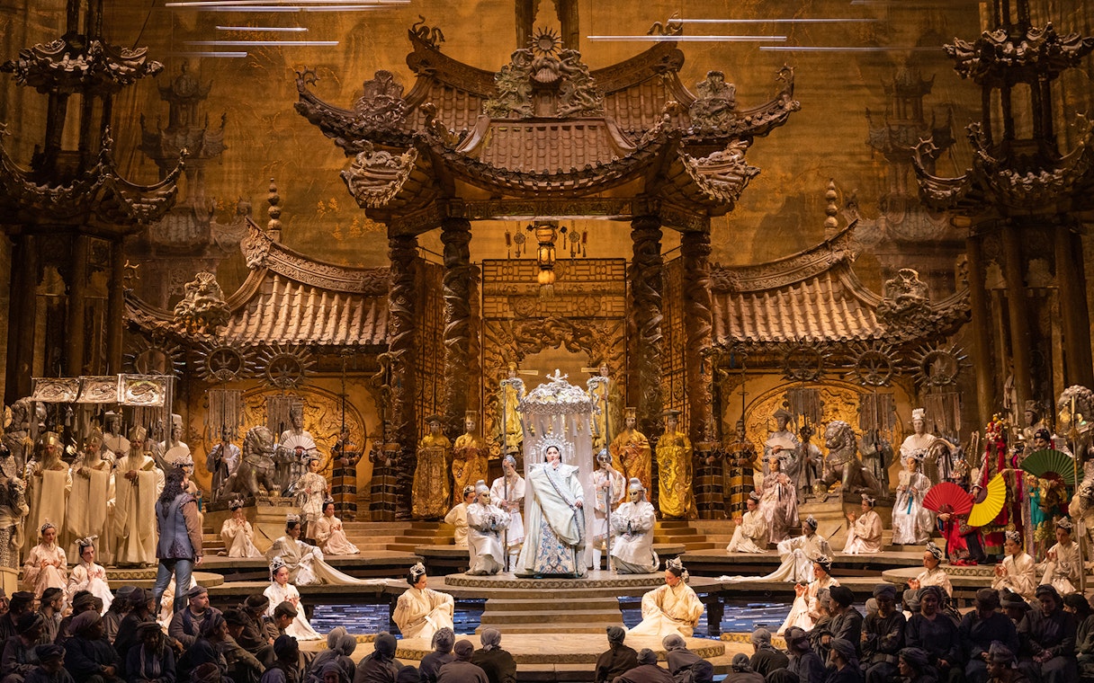 Opera performance of Turandot with elaborate set and costumed cast on stage.
