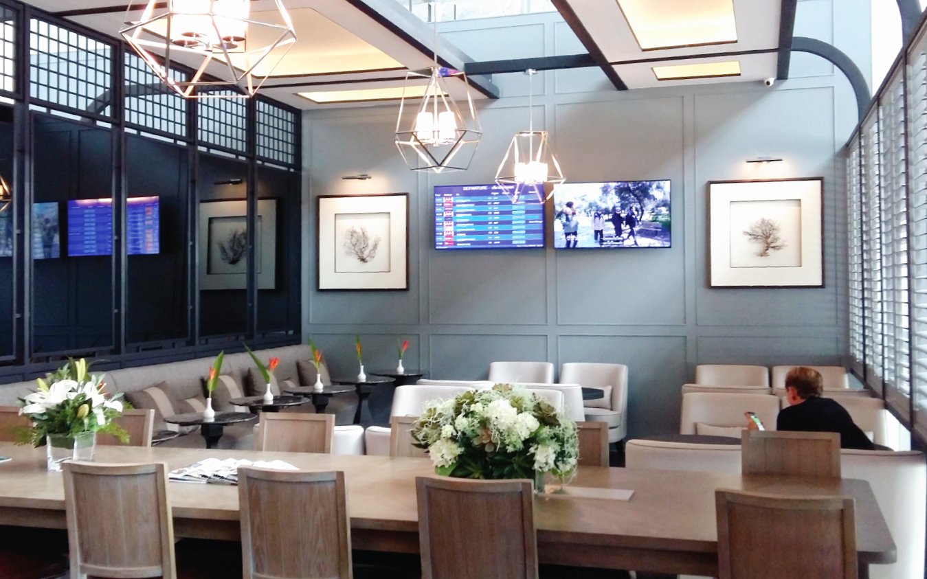 The Coral Executive Lounge at Phuket International Airport with seating and flight information screens.