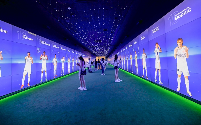 Visitors exploring digital displays at Santiago Bernabéu Stadium tour.