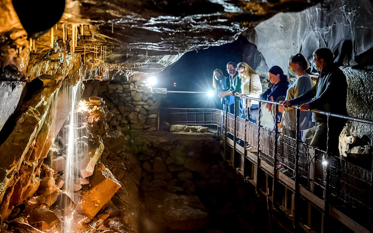 Visitors exploring Aillwee Cave's stalactites in County Clare, Ireland.