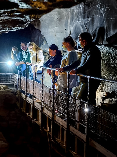 Visitors exploring Aillwee Cave's stalactites in County Clare, Ireland.