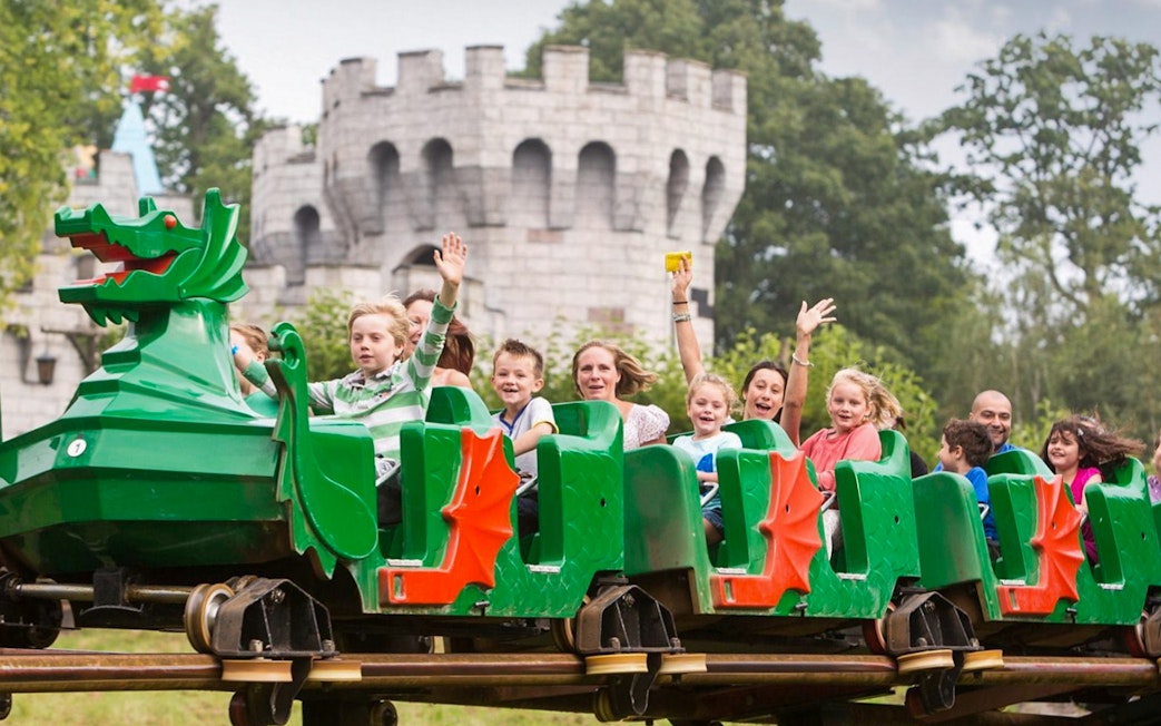 Visitors enjoying a dragon-themed roller coaster at LEGOLAND Windsor Resort.
