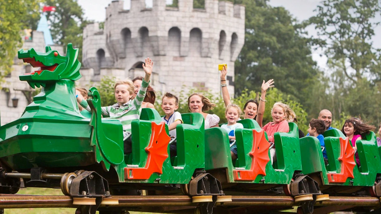 Visitors enjoying a dragon-themed roller coaster at LEGOLAND Windsor Resort.