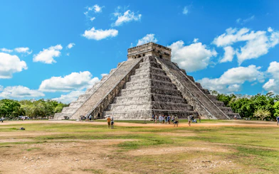 Chichen Itza pyramid with tourists exploring the site in Mexico.