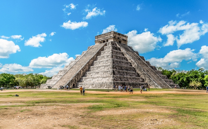 Chichen Itza pyramid with tourists exploring the site in Mexico.