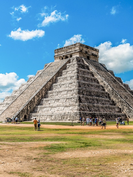 Chichen Itza pyramid with tourists exploring the site in Mexico.