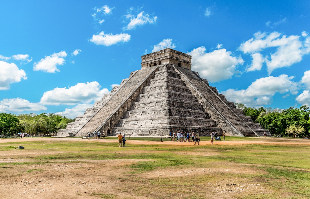 Chichen Itza pyramid with tourists exploring the site in Mexico.