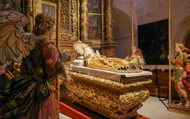 Religious statues in Palma Cathedral depicting angels around a golden altar.