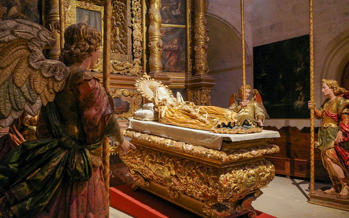 Religious statues in Palma Cathedral depicting angels around a golden altar.