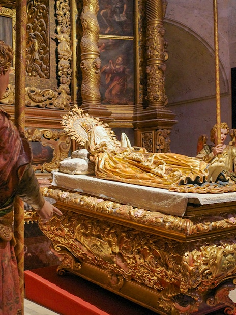 Religious statues in Palma Cathedral depicting angels around a golden altar.