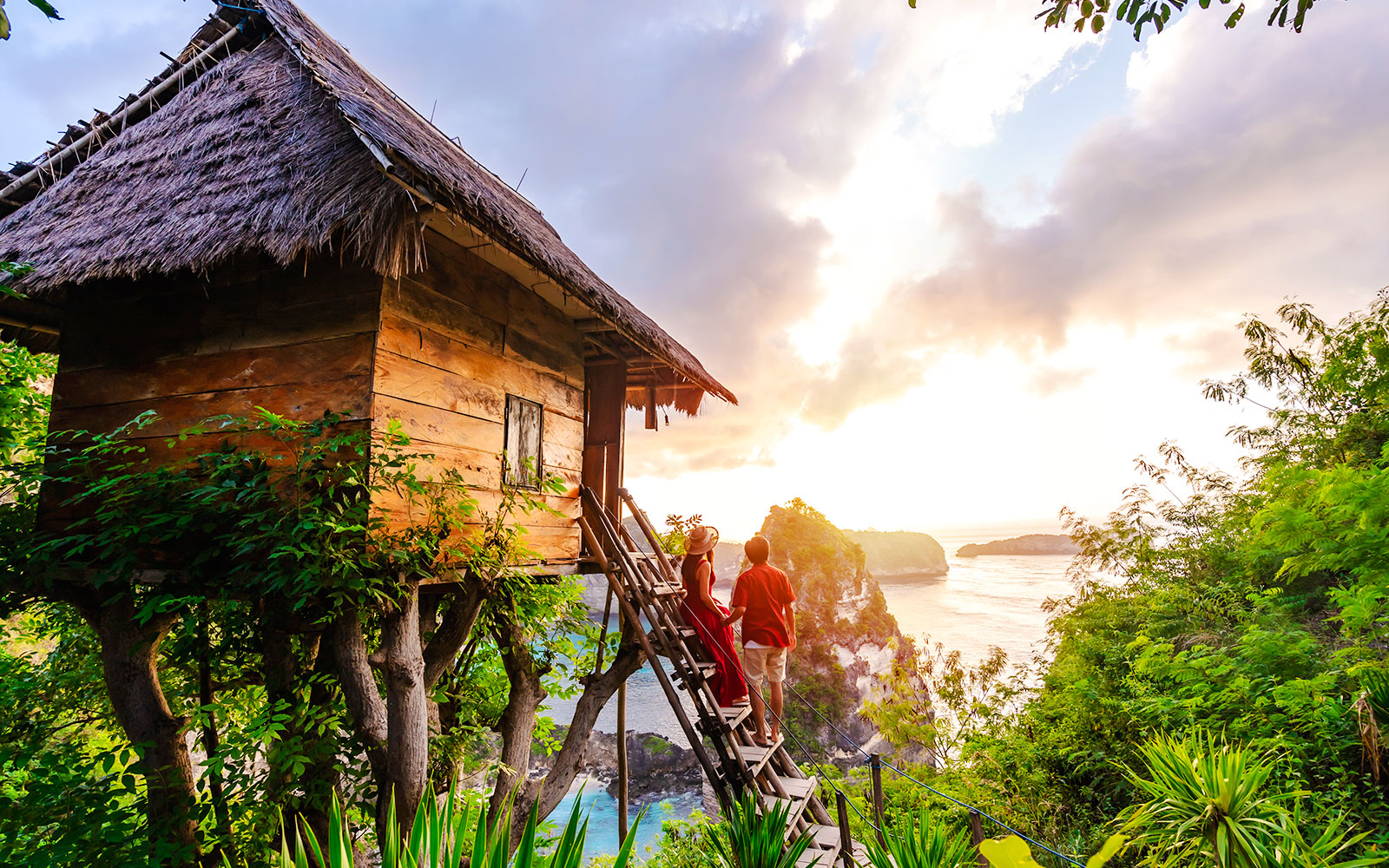 Tree house overlooking ocean cliffs at sunset in Nusa Penida.