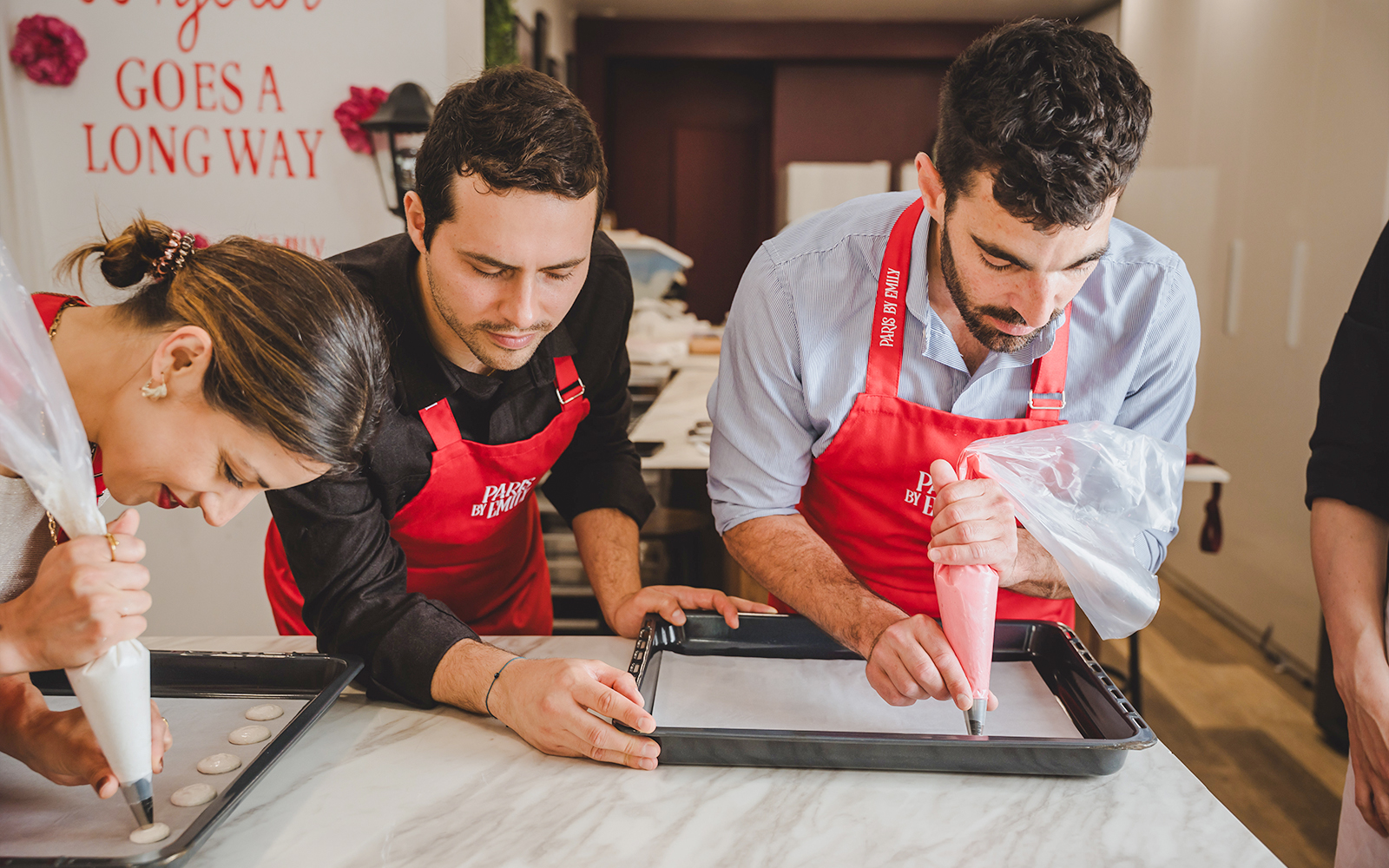 Participants piping macarons in a Paris workshop.