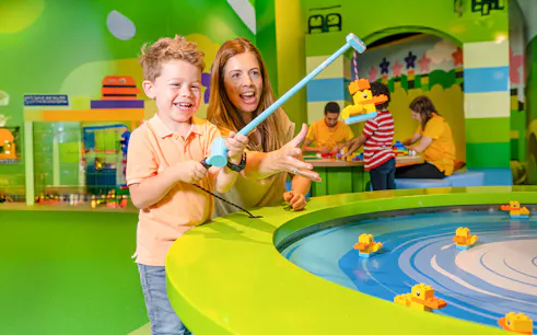 Child and adult playing with LEGO ducks at LEGO Discovery Centre Hamburg.