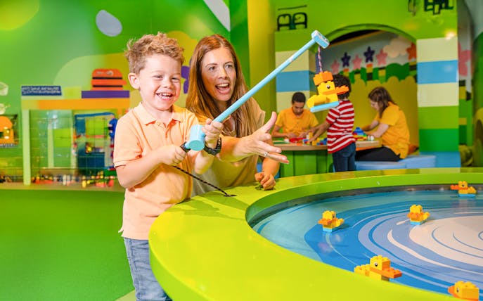 Child and adult playing with LEGO ducks at LEGO Discovery Centre Hamburg.