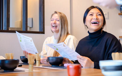 Friends enjoying a matcha-making class in Tokyo with Japanese sweets.