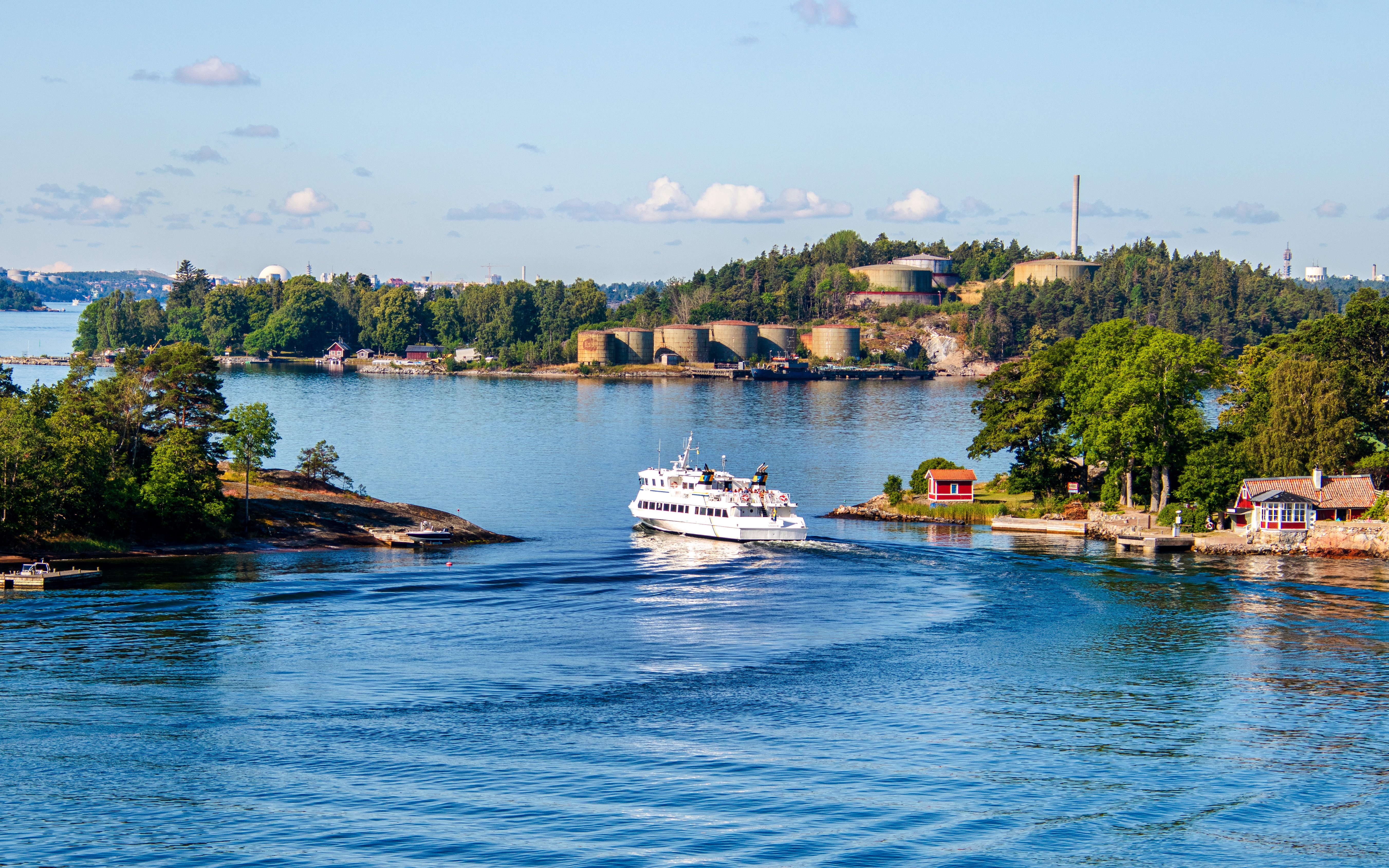 Boat navigating through the Stockholm archipelago, Sweden, with lush islands and coastal homes.