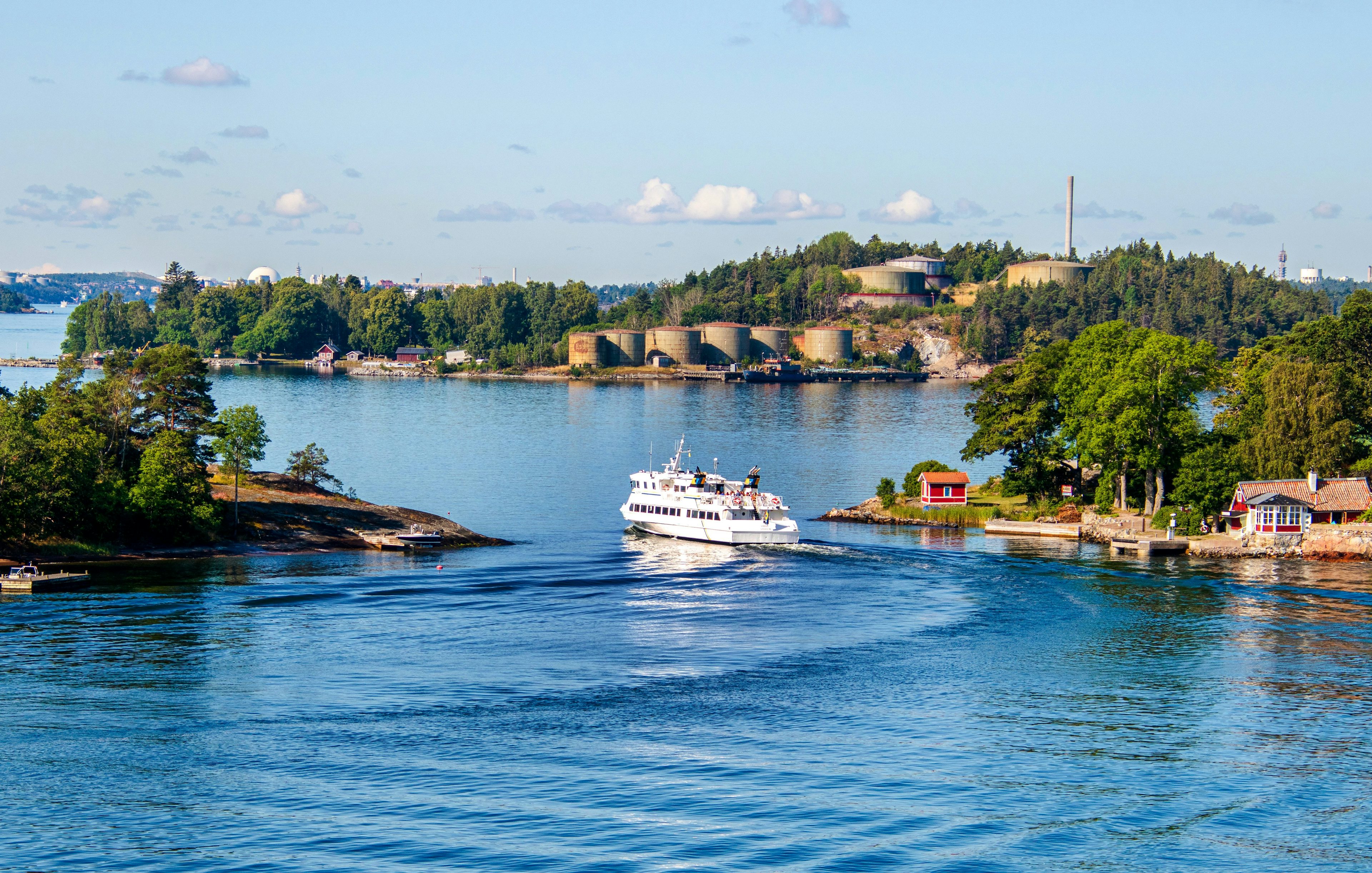 Boat navigating through the Stockholm archipelago, Sweden, with lush islands and coastal homes.