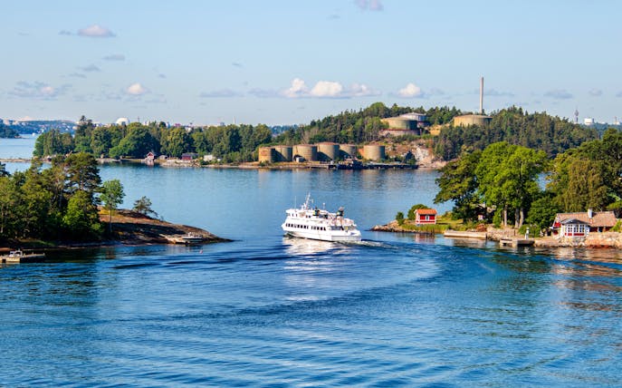Boat navigating through the Stockholm archipelago, Sweden, with lush islands and coastal homes.