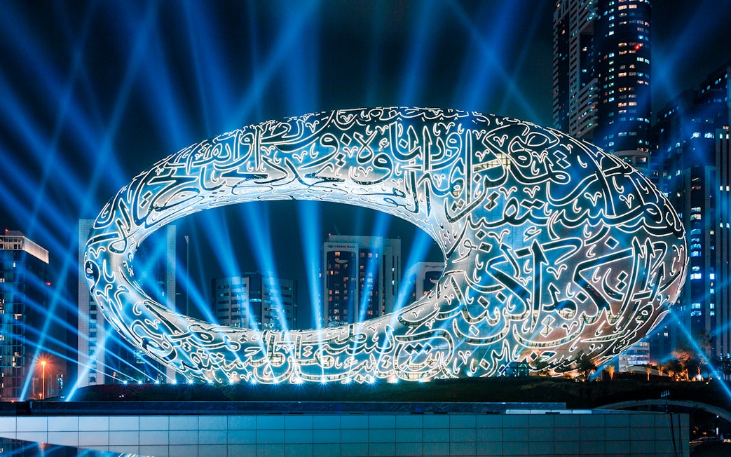 Futuristic architecture of the Museum of The Future in Dubai illuminated at night.