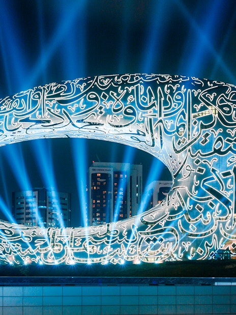 Futuristic architecture of the Museum of The Future in Dubai illuminated at night.