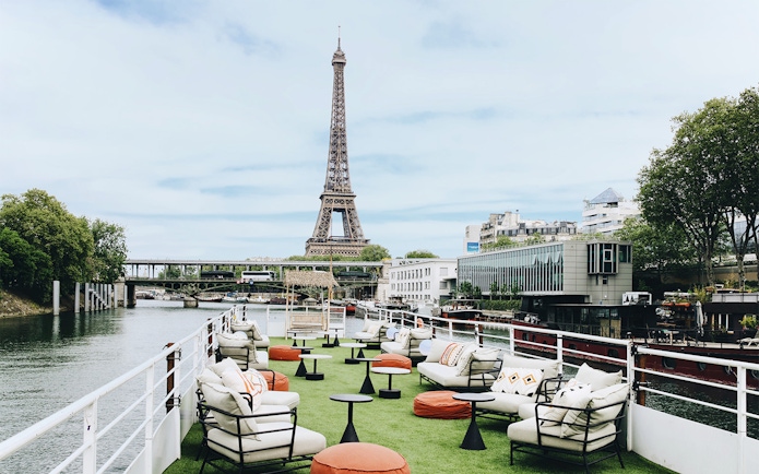 Rooftop seating on a boat cruise in Paris with Eiffel Tower view.