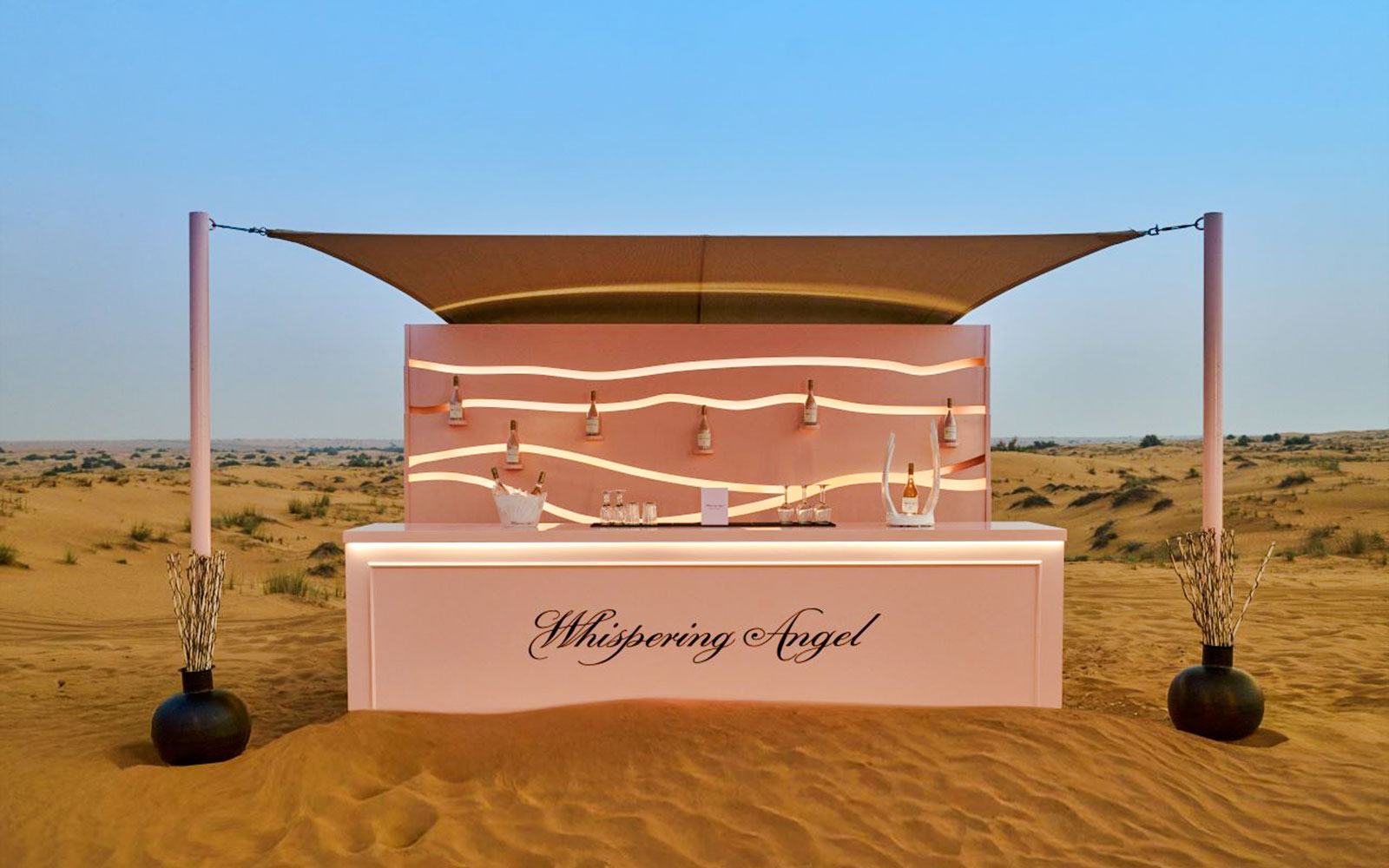 Bar counter at The Nomad Garden in the desert, featuring Whispering Angel wine bottles.
