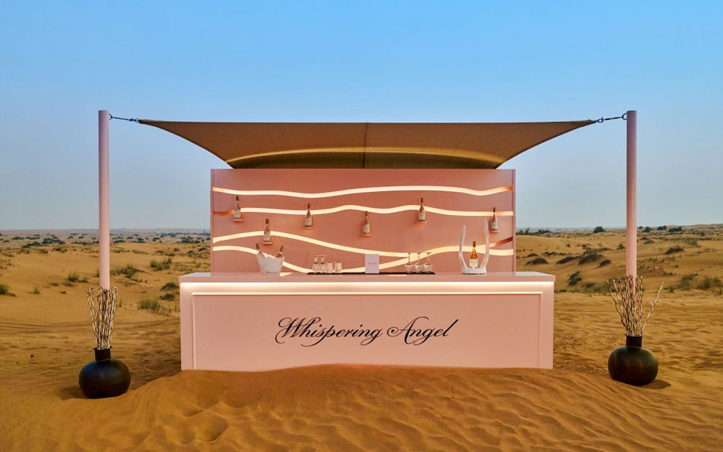 Bar counter at The Nomad Garden in the desert, featuring Whispering Angel wine bottles.