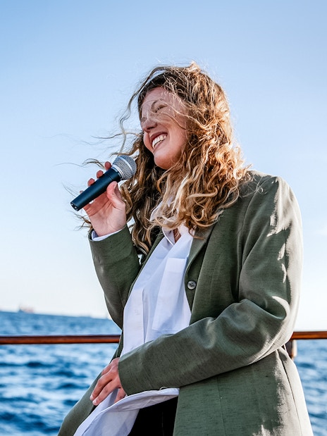 Person singing on a catamaran in Barcelona with ocean view.