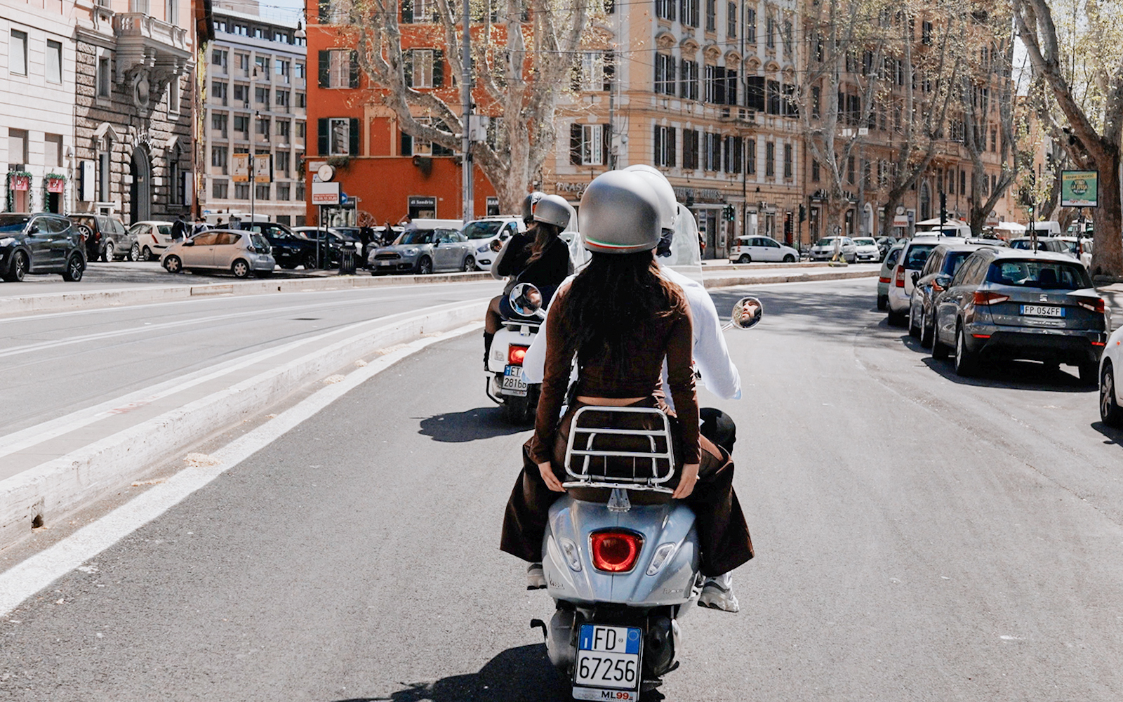 Tourists riding Vespas on a street in Rome, Italy.