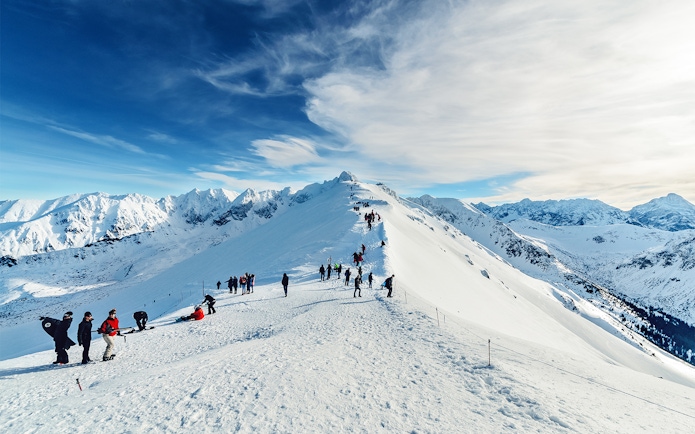 Group hiking on snow-covered ridge in Tatra Mountains, Poland.