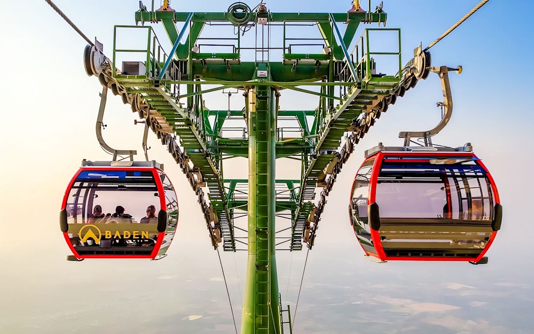 Cable car ascending Ba Den Mountains with passengers inside.
