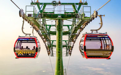 Cable car ascending Ba Den Mountains with passengers inside.