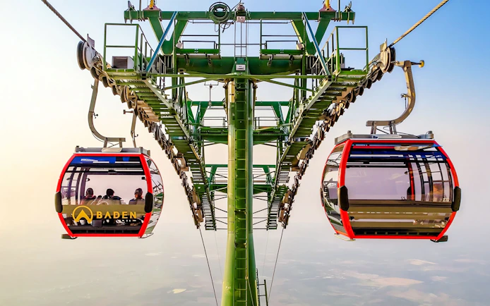 Cable car ascending Ba Den Mountains with passengers inside.