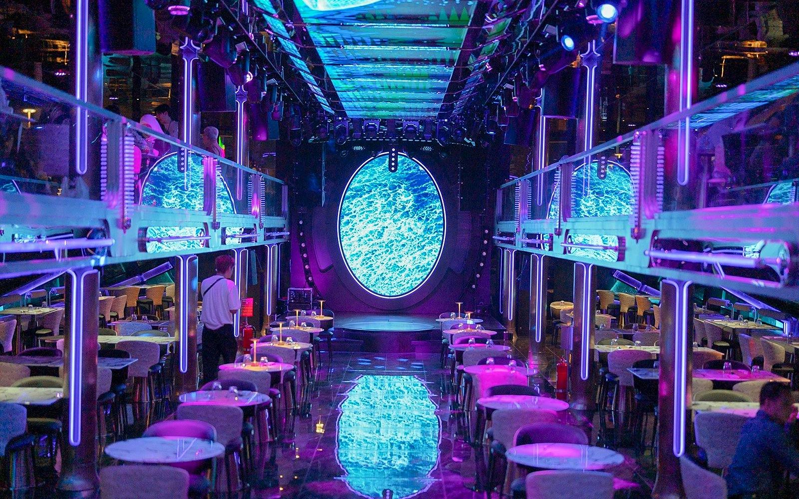 Luxury dining area on Super Galaxy Chao Phraya River Cruise with neon lights and ocean-themed decor.
