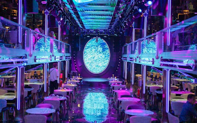 Luxury dining area on Super Galaxy Chao Phraya River Cruise with neon lights and ocean-themed decor.