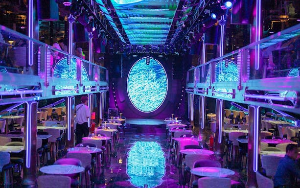 Luxury dining area on Super Galaxy Chao Phraya River Cruise with neon lights and ocean-themed decor.