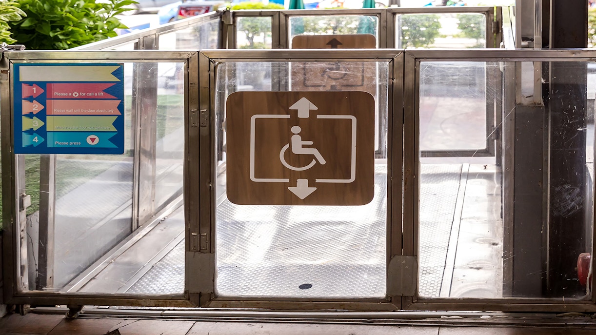 Wheelchair accessibility sign on a lift gate with instructions.