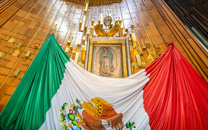 Our Lady of Guadalupe image inside Basilica of Guadalupe with Mexican flag.