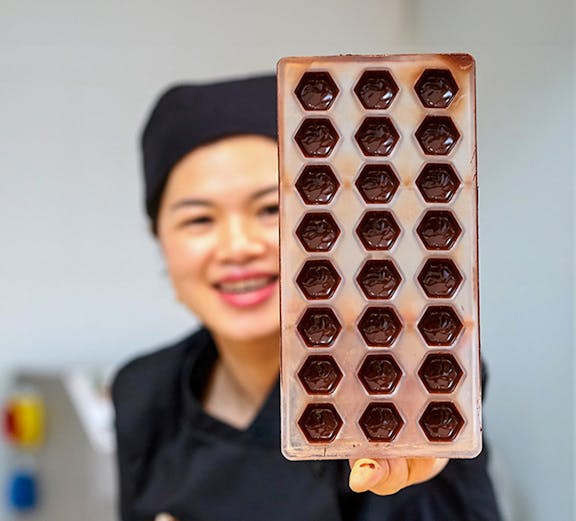 Chocolate mold held by a chocolatier at Choco-Story Brussels.