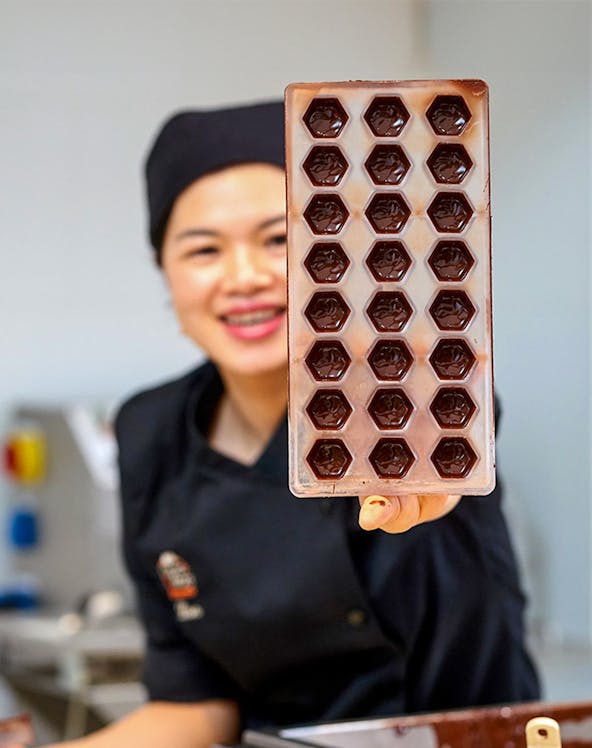 Chocolate mold held by a chocolatier at Choco-Story Brussels.