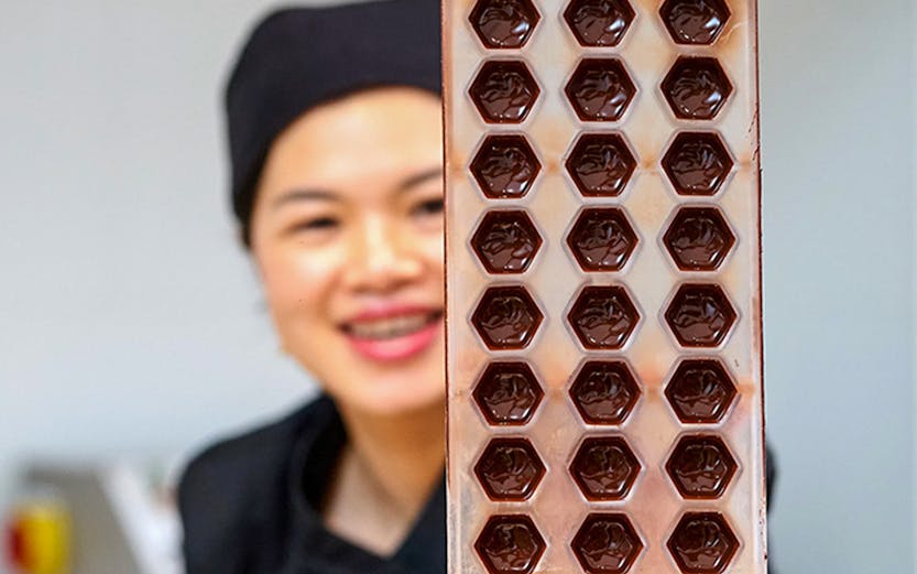 Chocolate mold held by a chocolatier at Choco-Story Brussels.