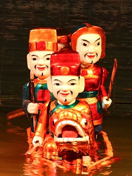 Golden Dragon Water Puppet performance with colorful figures in Hanoi, Vietnam.